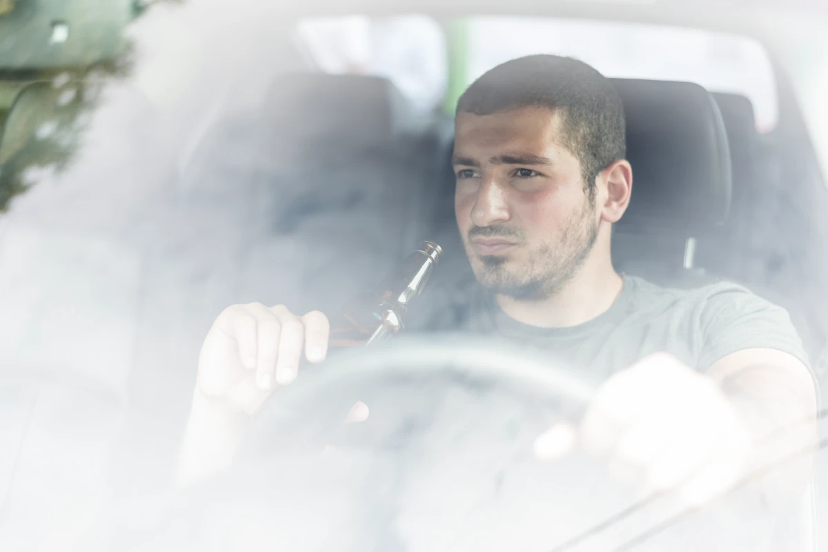 thoughtful man with beer driving car