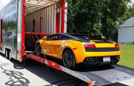 A yellow sport car being loaded onto a trailer for import.