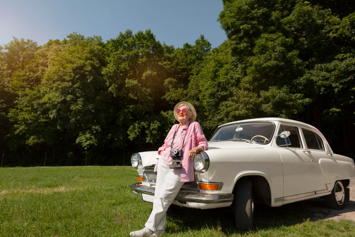 senior woman traveling with her classic white car