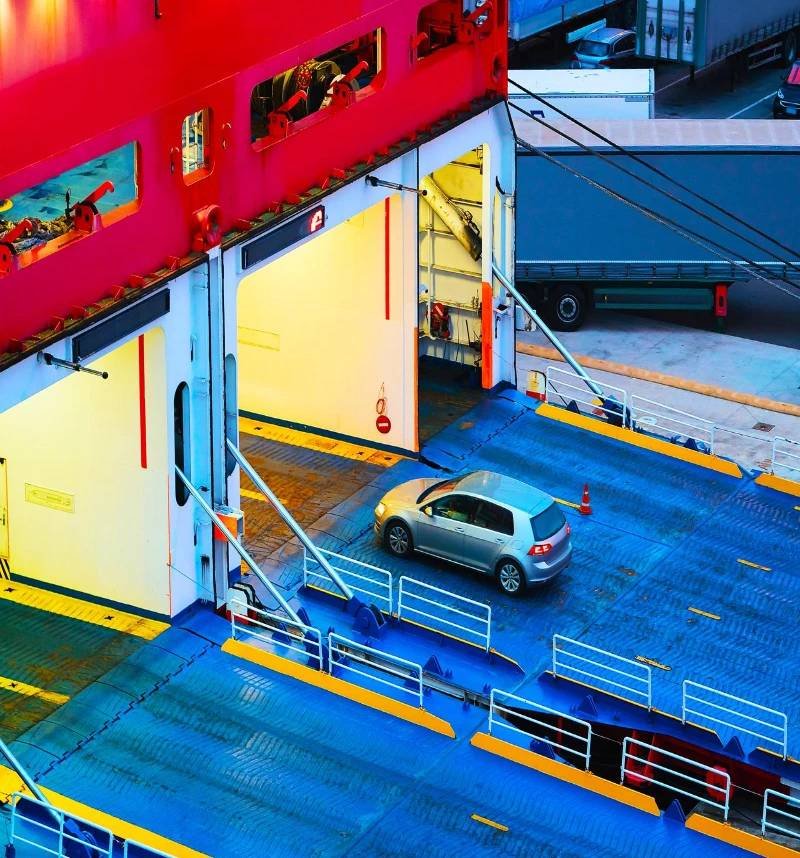 A car parked on a ferry, viewed from above, ready to be transported.