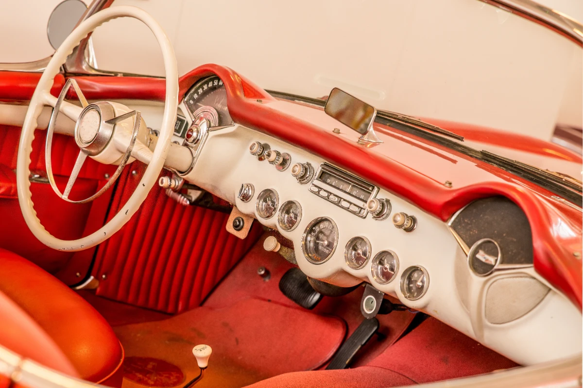 Interior of a classic car featuring vibrant red leather seats, exuding timeless elegance and luxury.